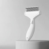 A white curved stainless steel grooming brush for long-haired pets featuring a professional ergonomic handle.
