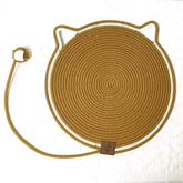 An earth soil brown cat face rope scratching mat showcasing its tightly woven natural fiber texture and integrated knotted tail extension for feline claw care.