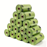 Multiple rolls of large, green pet waste bags containing 15 bags per roll for hygienic dog and cat cleanup.