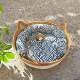 Handcrafted woven cat nest featuring a removable blue and white patterned cushion for pet comfort.