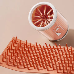 A group of portable dog paw cleaning cups in orange, green, and blue, each featuring soft silicone bristles and a detachable design for cleaning pet paws.