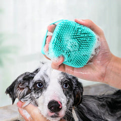 Light blue silicone pet bath brush with soft bristles and a top soap compartment.