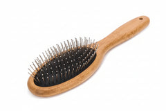 Close‑up of rounded stainless steel needle tips on pet grooming brush