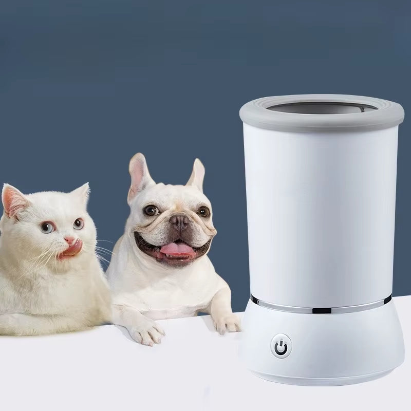 A white USB rechargeable automatic dog and cat paw washer with soft silicone bristles, shown beside a dog and a cat on a solid background.