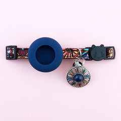 An adjustable navy blue breakaway AirTag cat collar featuring an intricate Bohemian print pattern and an integrated silicone tracker pocket.