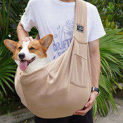 A neutral coyote desert khaki colored pet sling carrier bag demonstrating its comfortable, close-to-body ergonomic tracking profile.
