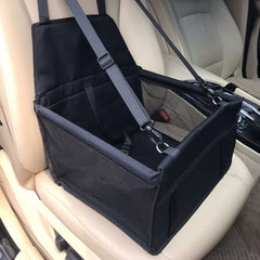 Black dog car seat carrier with mesh panels, safety straps, and elevated booster design installed on a front passenger seat.