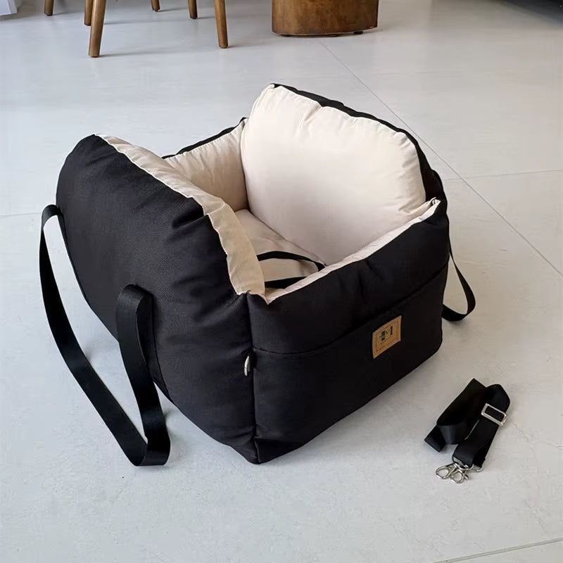Black soft dog car seat with beige cushion, safety belt, and storage pockets designed for small dogs and cats.