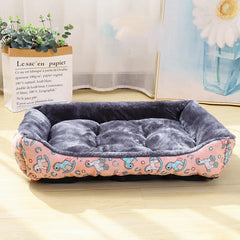 A pink printed winter cushion mat for pets featuring raised bolster edges for neck support.