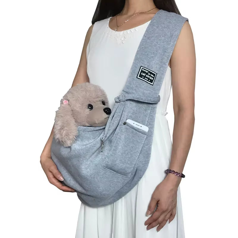 A light arctic mist grey soft-sided pet carrying sling laying flat to demonstrate its breathable woven fabric construction and nest-like interior.