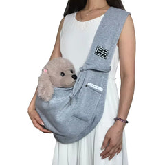 A light arctic mist grey soft-sided pet carrying sling laying flat to demonstrate its breathable woven fabric construction and nest-like interior.