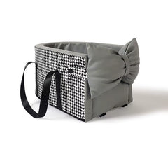 Black and white houndstooth pet car seat with grey bow, padded interior, and carrying straps for small dogs and cats.