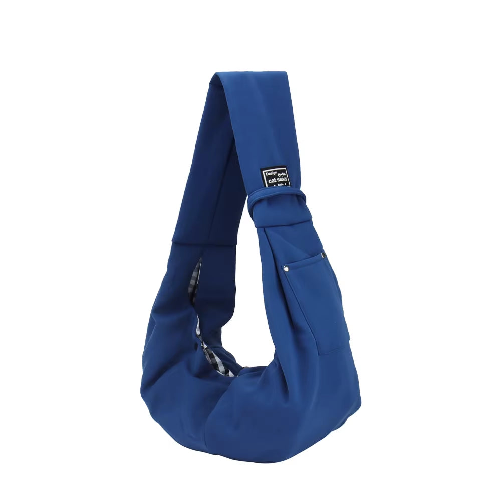 Blue pet shoulder sling bag with outer pocket and wide strap, suitable for carrying small pets during travel or walks.