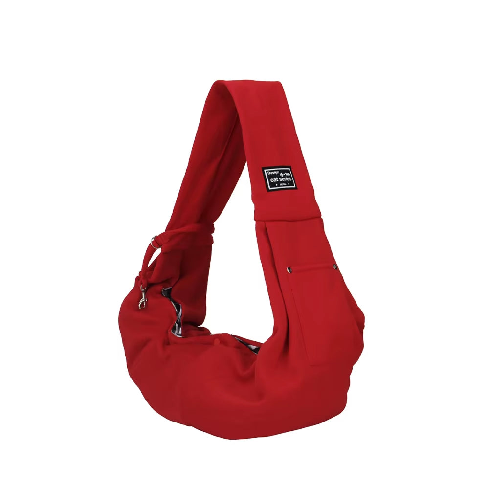 Red pet shoulder sling bag with wide padded strap and secure zippered opening designed for carrying small dogs or cats.