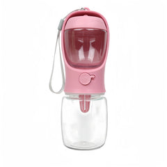 Pink portable pet water bottle featuring a built‑in bowl, transparent water container, and wrist strap for easy carrying.