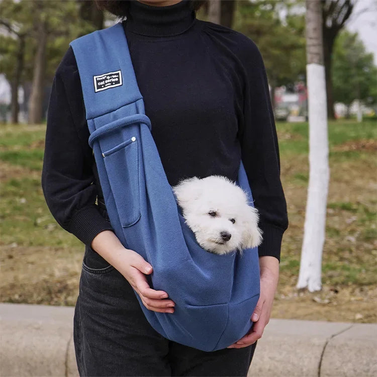 A vibrant ocean marine blue soft-sided pet travel sling highlighting its lightweight polyester material and integrated smartphone utility pocket.