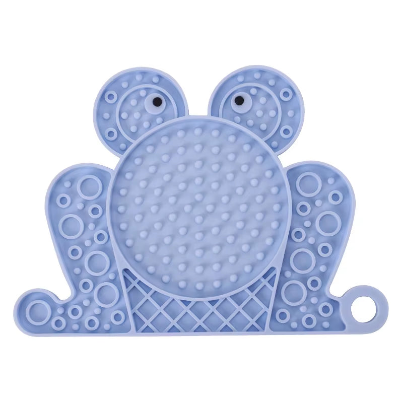A blue frog-shaped anti-anxiety licking pad made of non-toxic silicone for slow feeding and pet distraction.