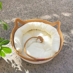 Handcrafted woven cotton rope cat bed with a soft cream-white plush removable cushion.